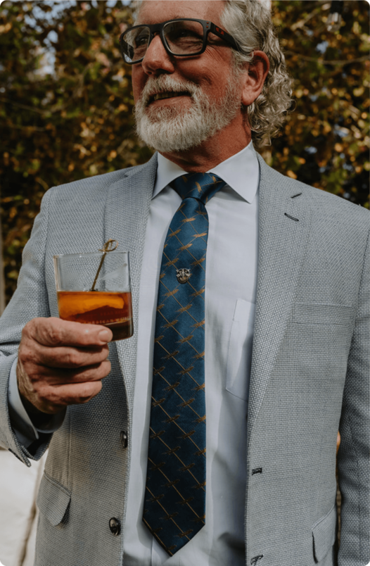 Brad Halling in suit holding BHAWK whiskey glass